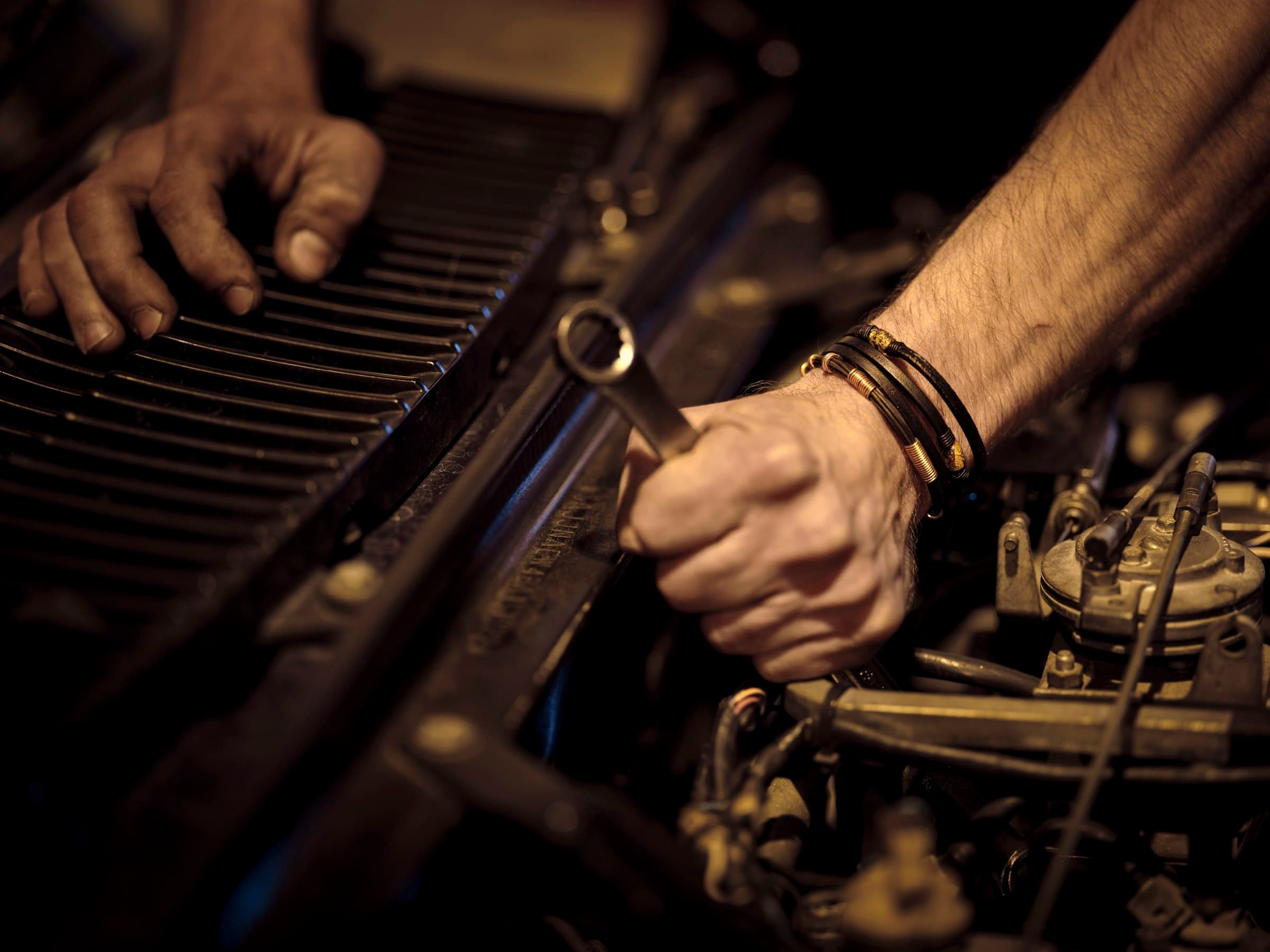 A mechanic's hands at work in an engine bay